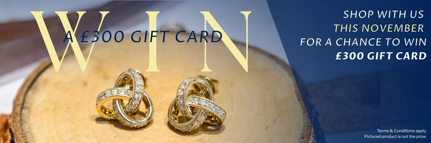 Gold earrings on a wooden surface with promotional text for a chance to win a £300 gift card.